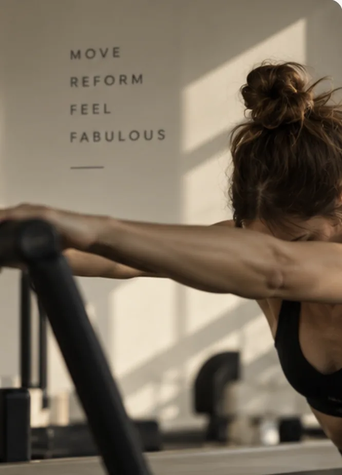 A member on the reformer in front of the Move, Reform, Feel Fabulous wall